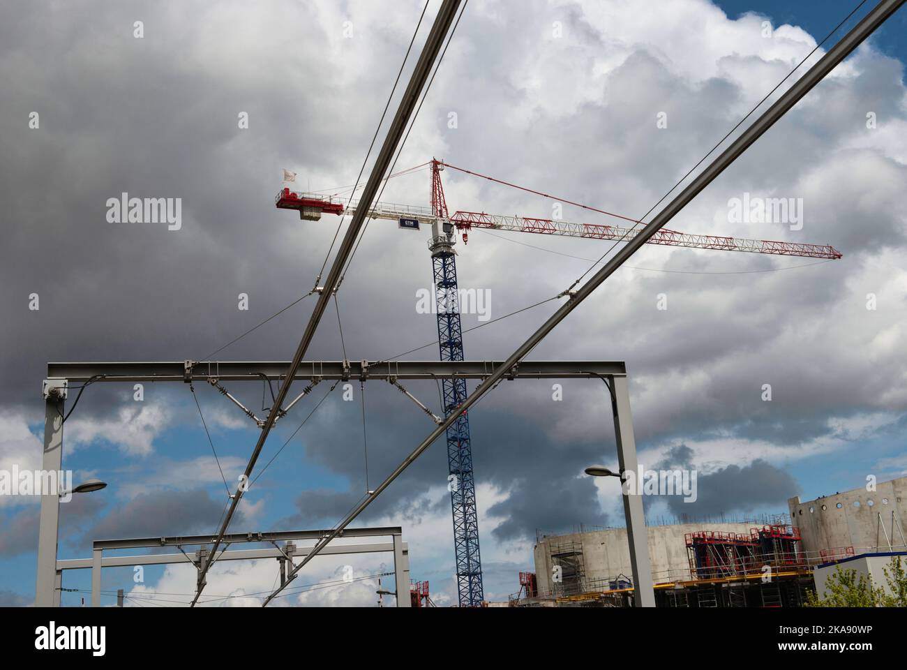 A low angle shot of cranes and construction sites against a cloudy sky ...