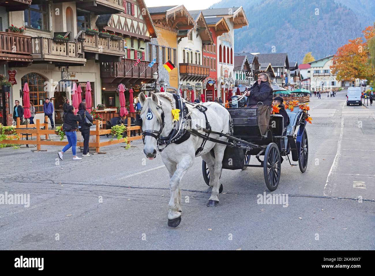 A horse drawn carriage carries tourists and visitors around the streets of the small, Bavarian-style town of Leavenworth, Washington. Stock Photo