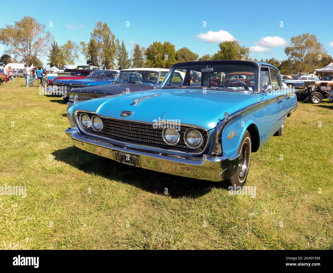 Old blue Ford Galaxie Starliner four door sedan 1970 in the countryside. Nature, grass, trees. Classic car show. Copyspace Stock Photo