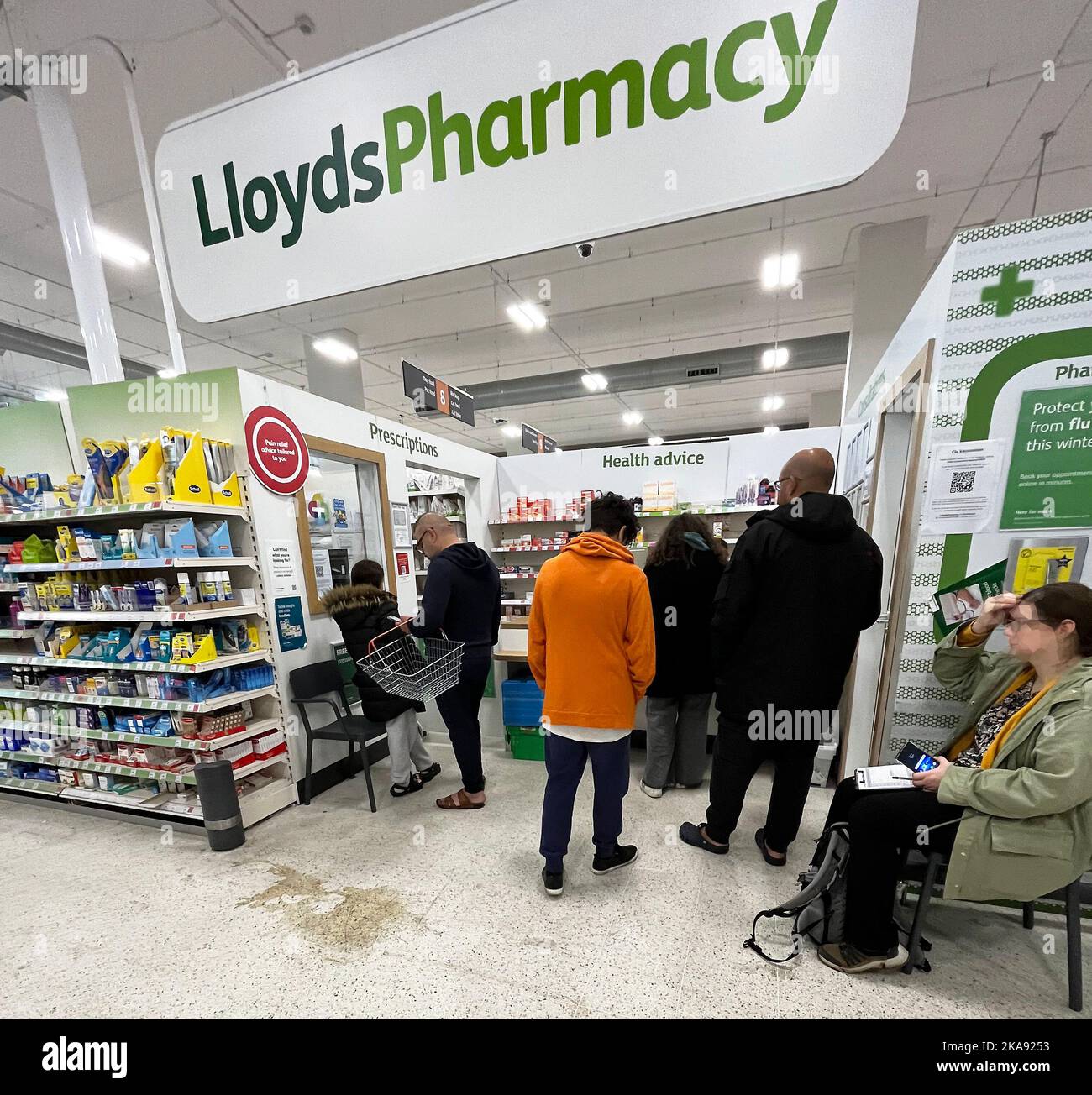 People wait at Lloyds Pharmacy inside Sainsburys, Wandsworth, London