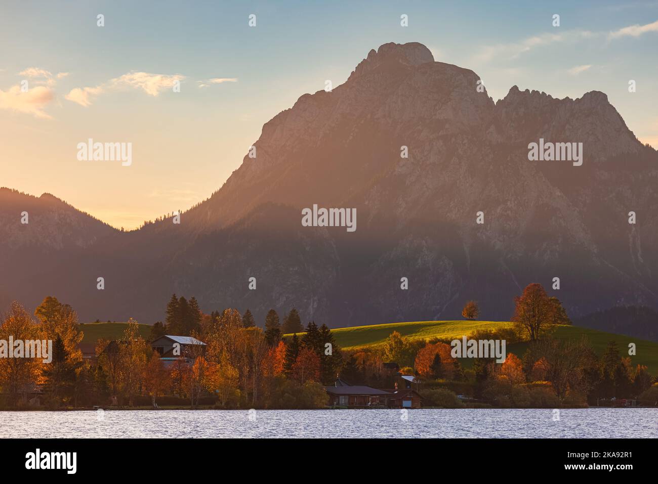 An autumn sunrise at Lake Hopfen (Hopfensee in German) with the Allgauer Alps in the background. Located in Bavaria, southern Germany. Stock Photo