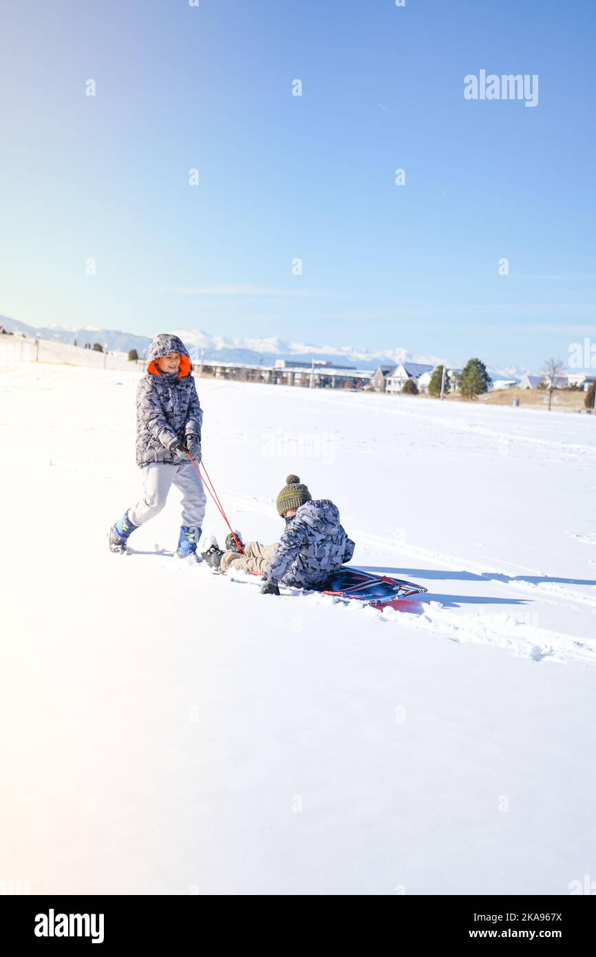 Children laughter have fun sledding on a sunny day on winter denver Stock Photo