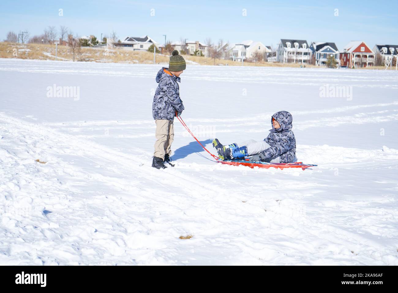 Children laughter have fun sledding on a sunny day on winter denver Stock Photo