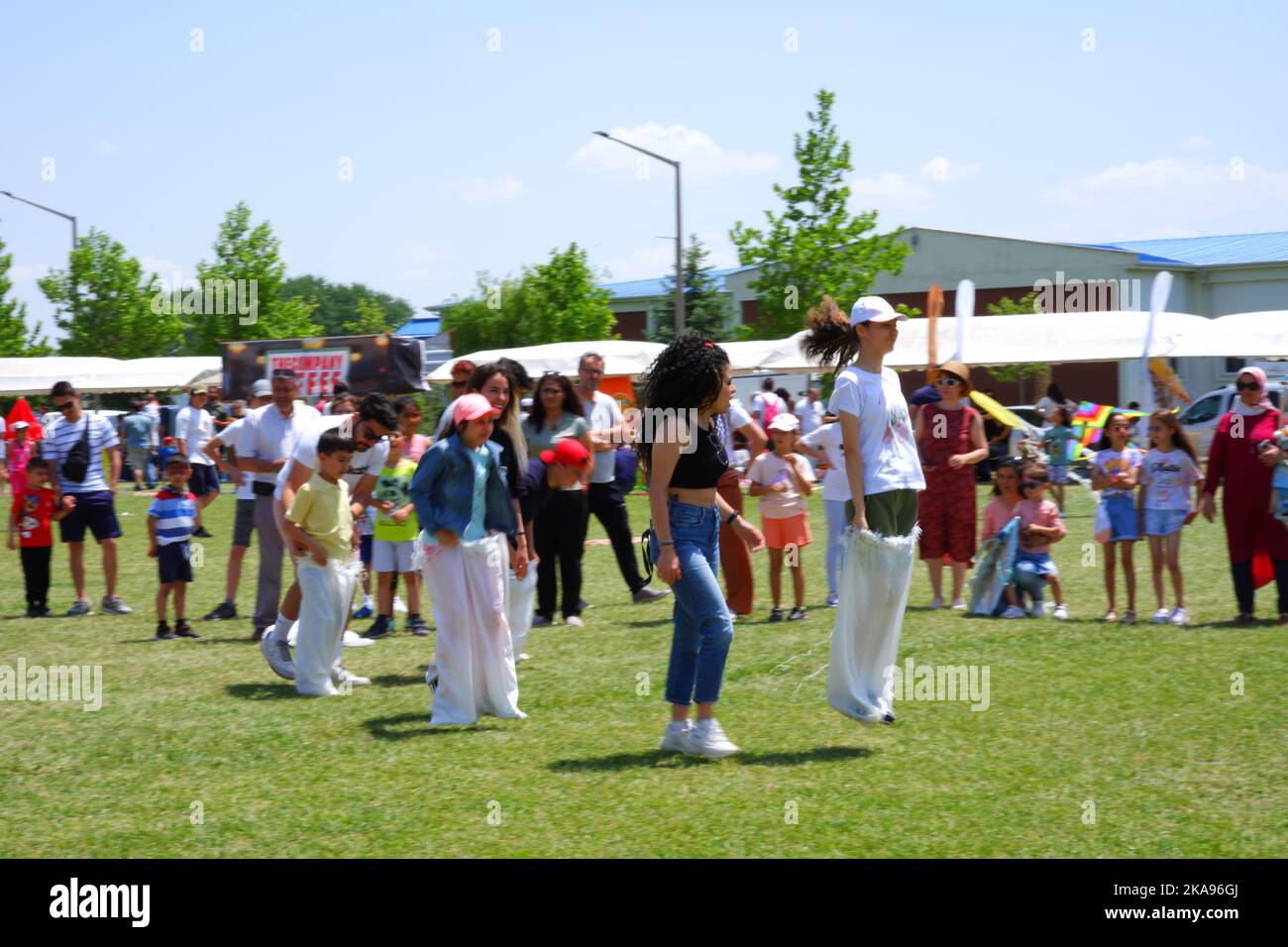 People having fun at gunnysack race on grass in a sunny day. Laughing ...