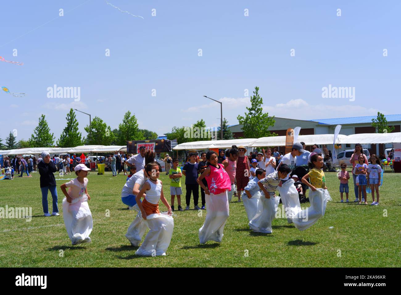 People having fun at gunnysack race on grass in a sunny day. Laughing ...