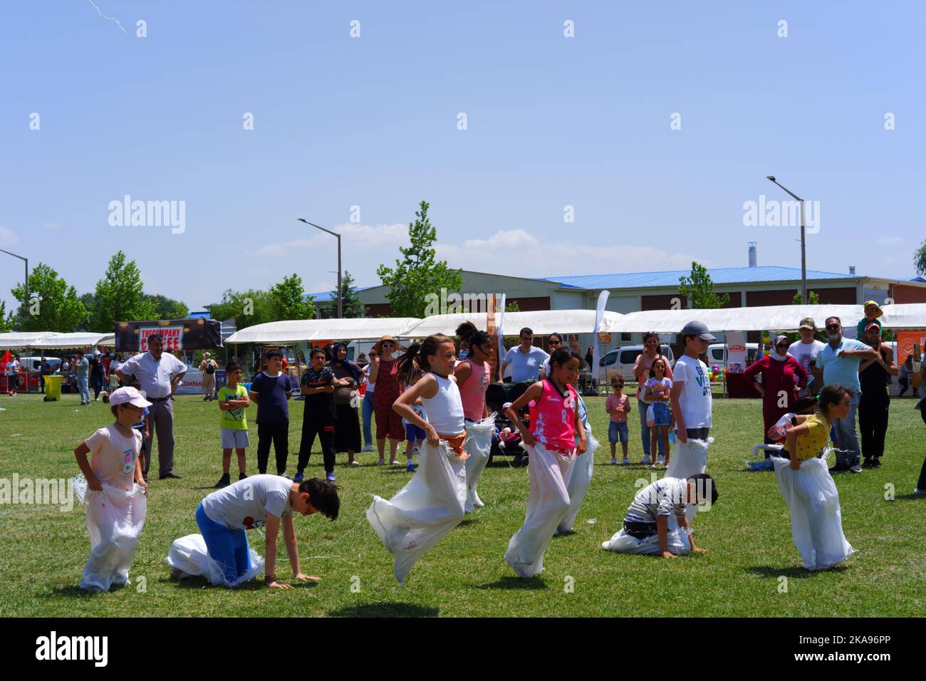 People having fun at gunnysack race on grass in a sunny day. Laughing ...