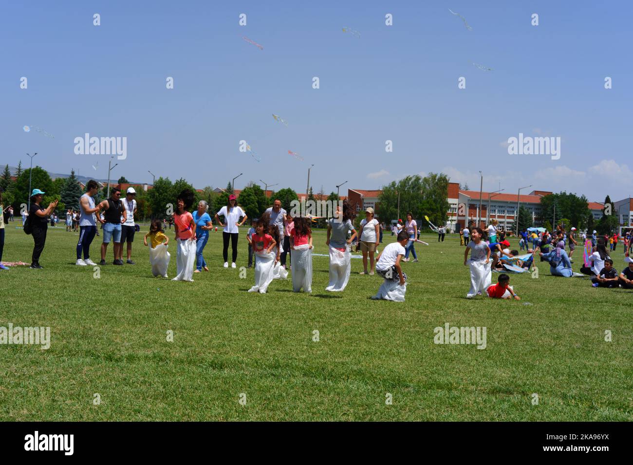 People having fun at gunnysack race on grass in a sunny day. Laughing ...