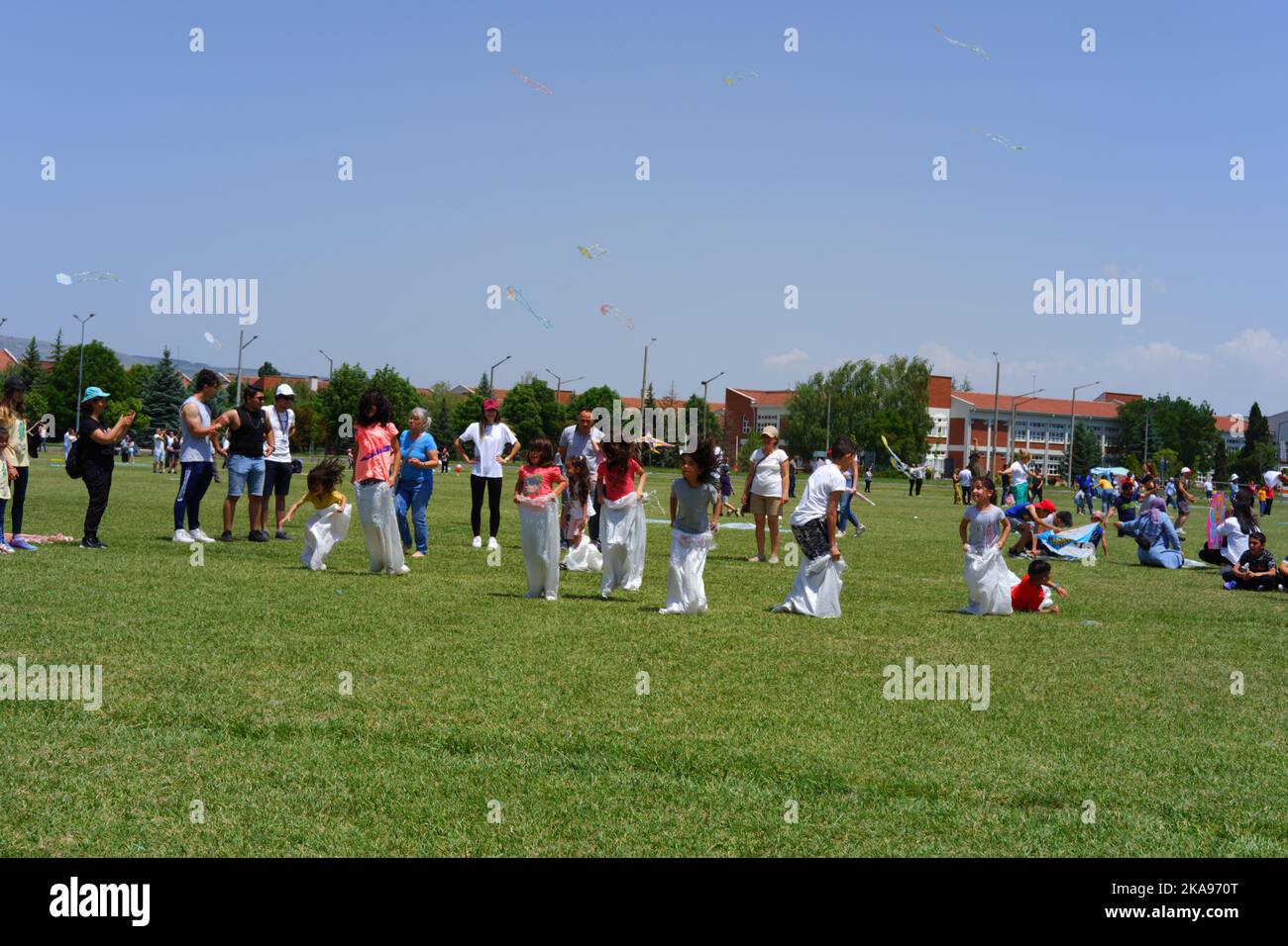 People having fun at gunnysack race on grass in a sunny day. Laughing ...