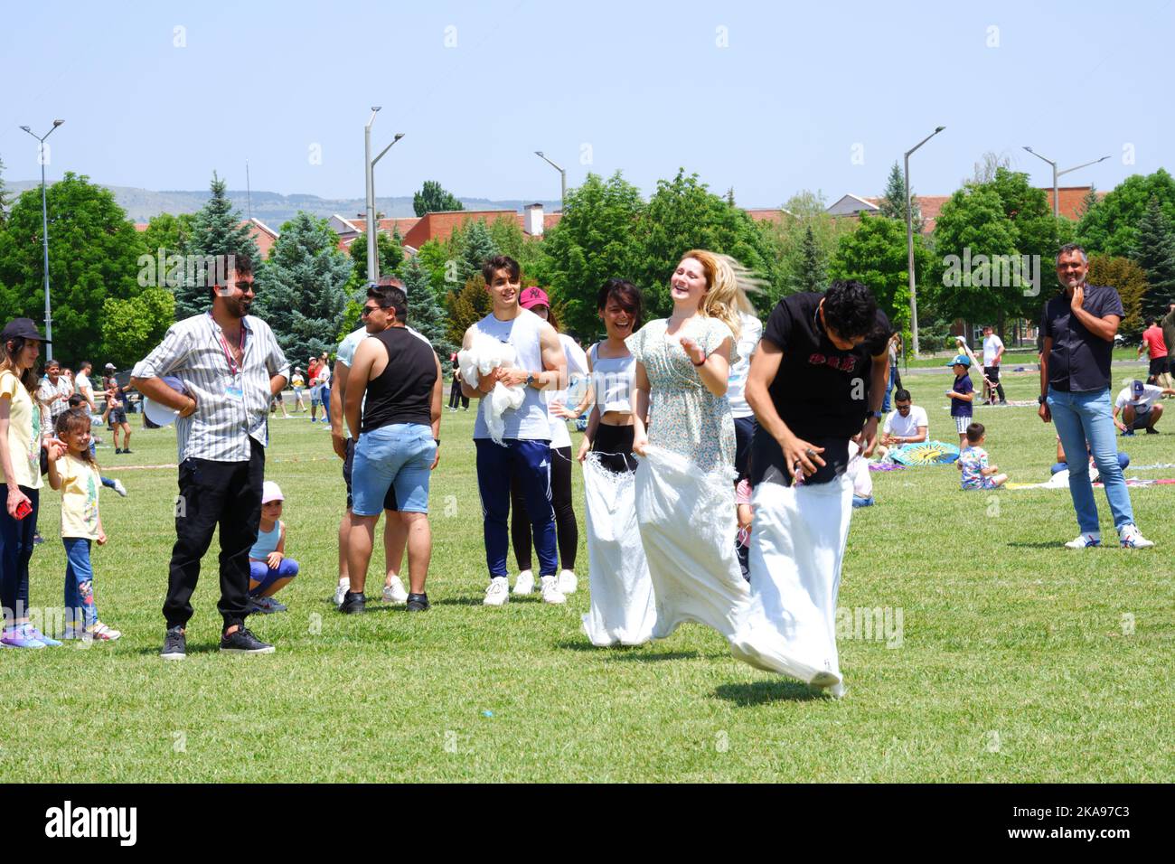 People having fun at gunnysack race on grass in a sunny day. Laughing ...