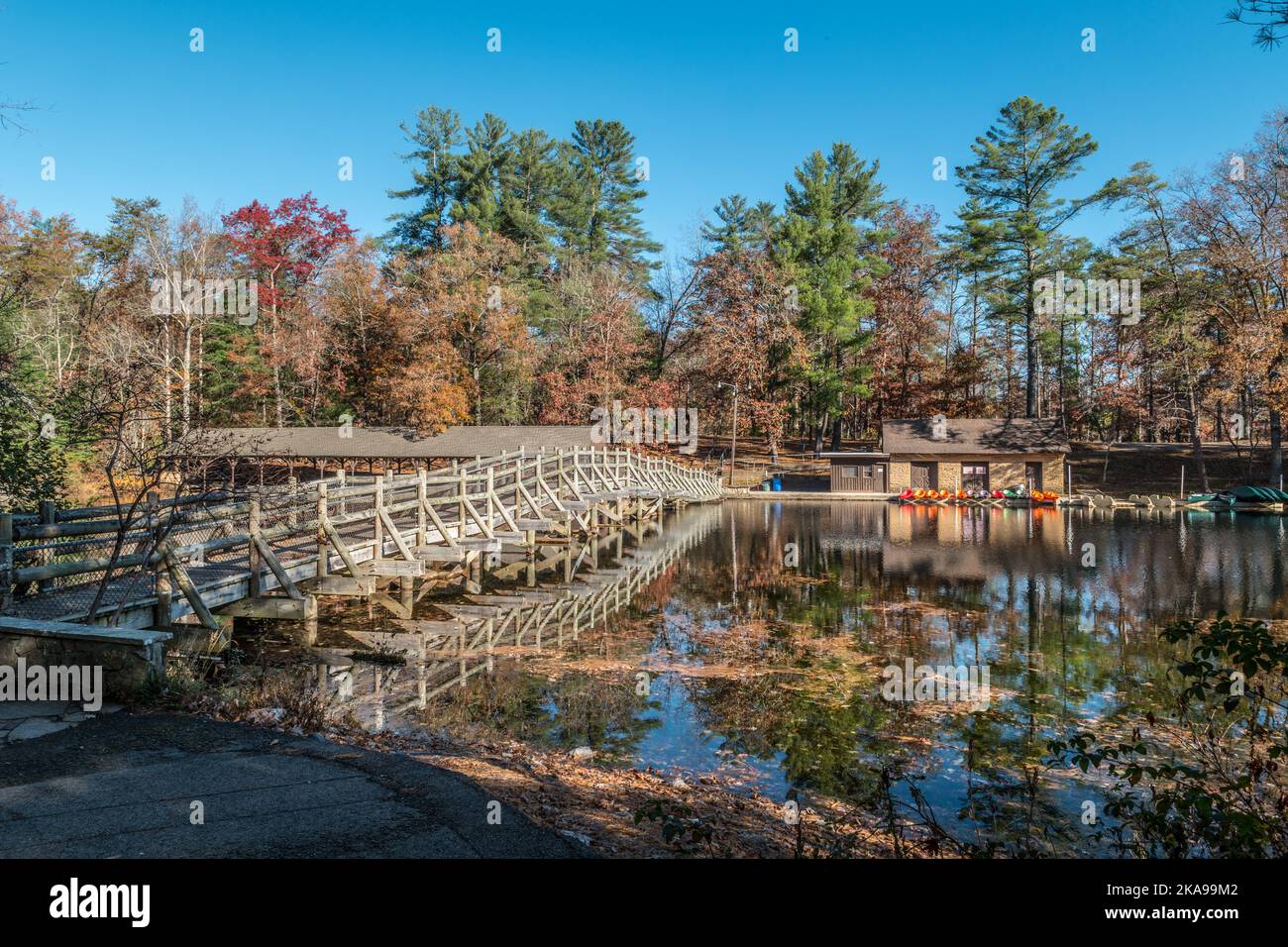 Crossing over the wooden bridge across from the boat rentals on Byrd lake in the Cumberland mountain state park in Tennessee on a bright sunny day in Stock Photo