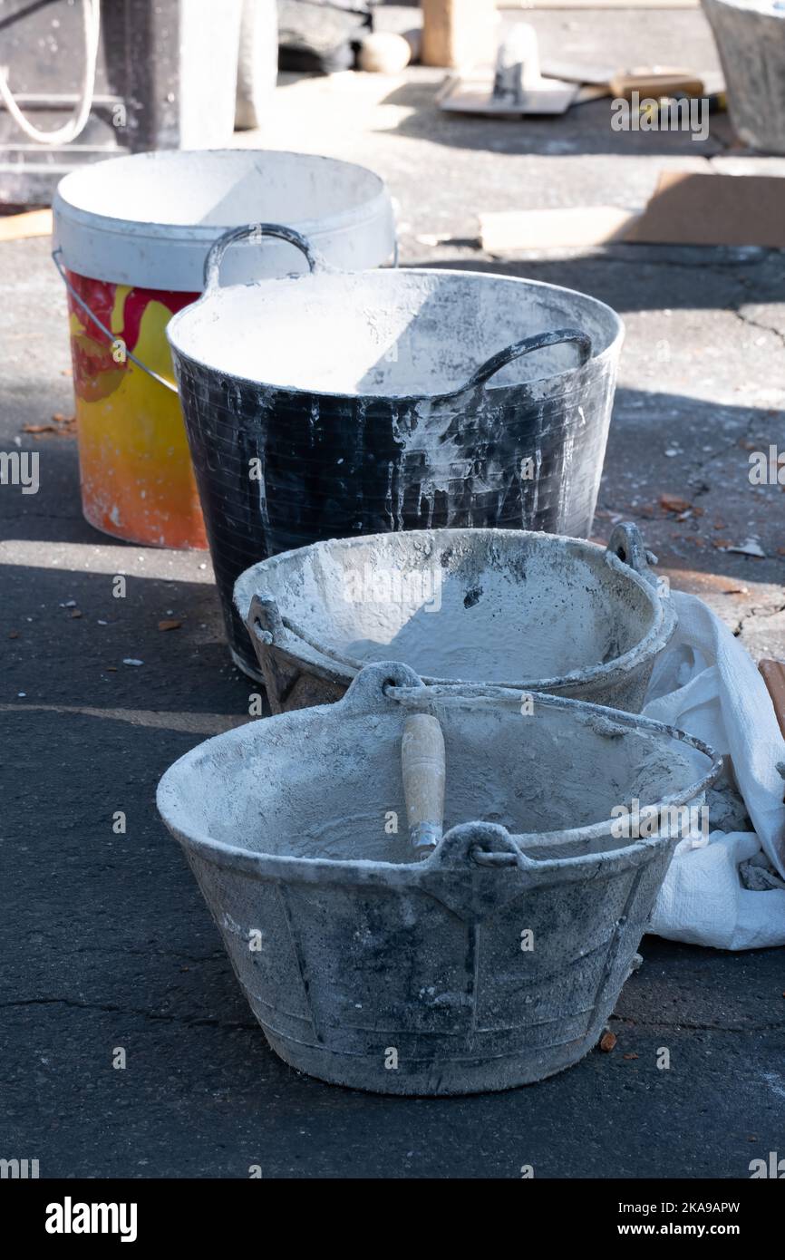 Various buckets for plaster and cement with a trowel on a construction