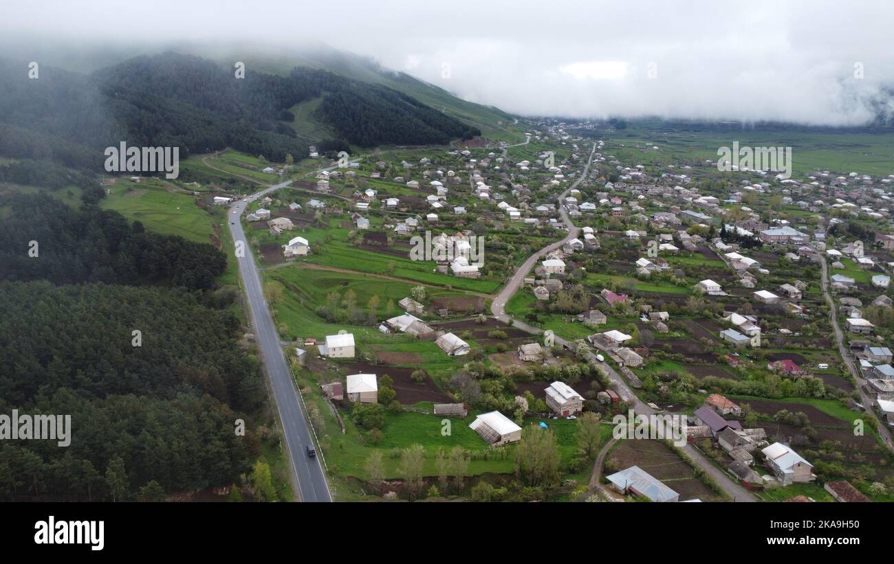 The bird's eye view of the rural houses in the green valley. Lori
