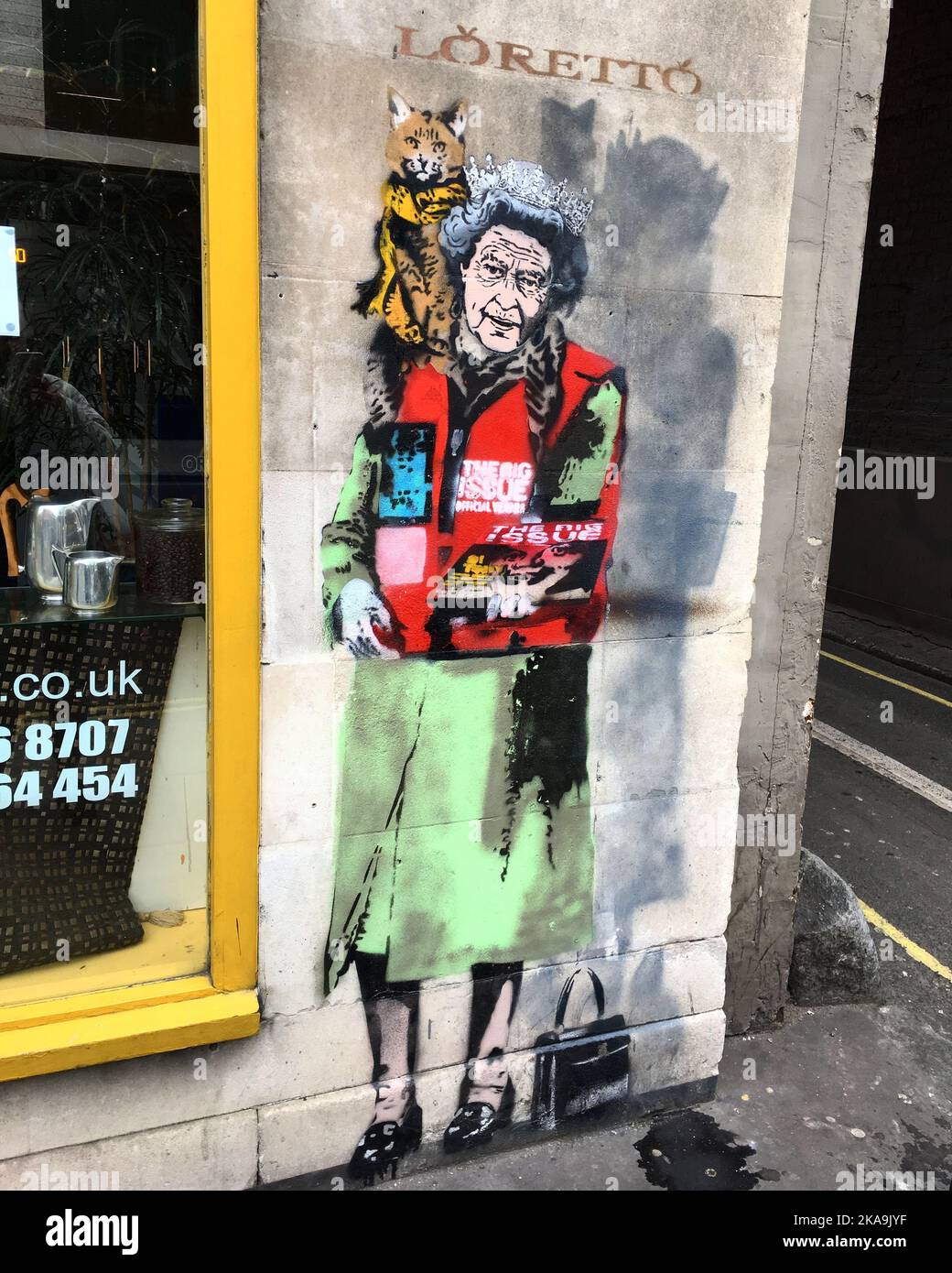 A vertical shot of a graffiti art of the queen with a cat on the streets of London, United Kingdom Stock Photo