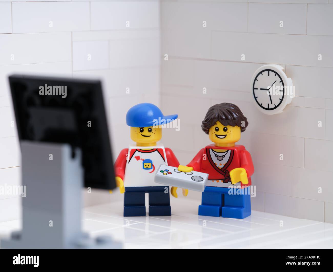 Tambov, Russian Federation - September 6, 2022 Two Lego kid minifigures playing a video game using a gamepad. Stock Photo