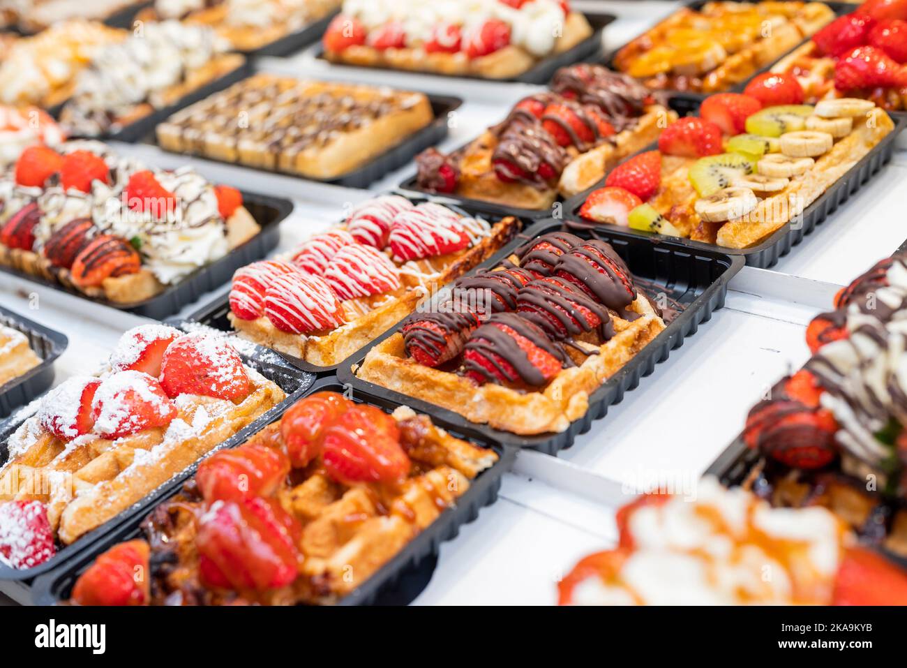 national food waffles in Belgium on the square in pastry shops with chocolate cream and berries Stock Photo
