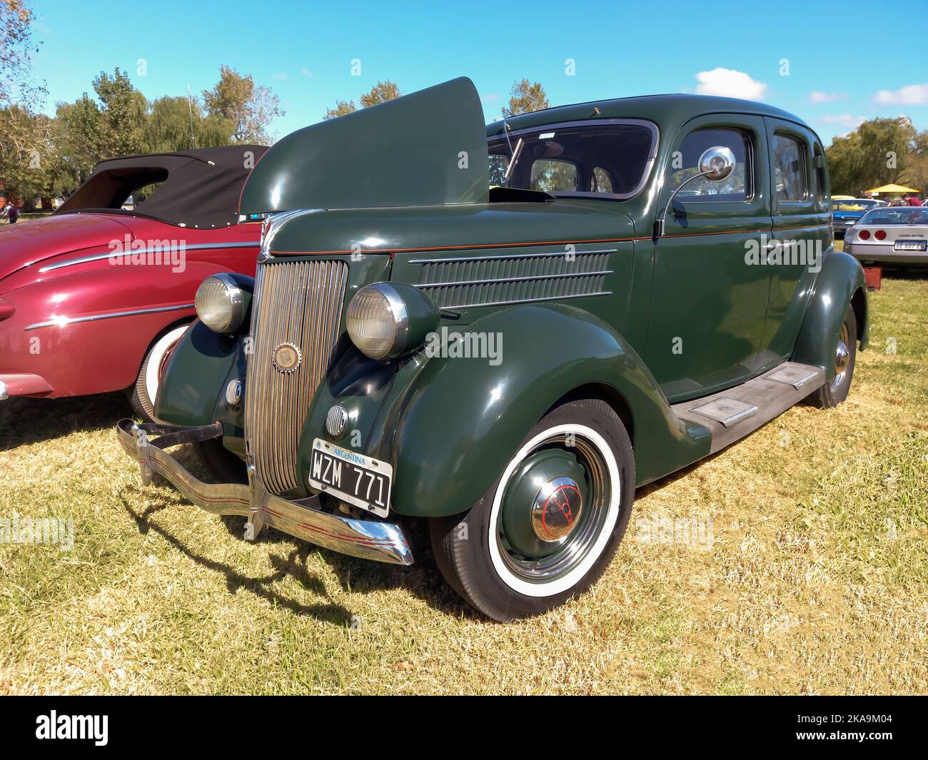 Chascomus, Argentina - Apr 9, 2022: Vintage green Ford Model 48 V8 Fordor sedan 1936 in the countryside. Nature, grass, trees. Classic car show. Stock Photo