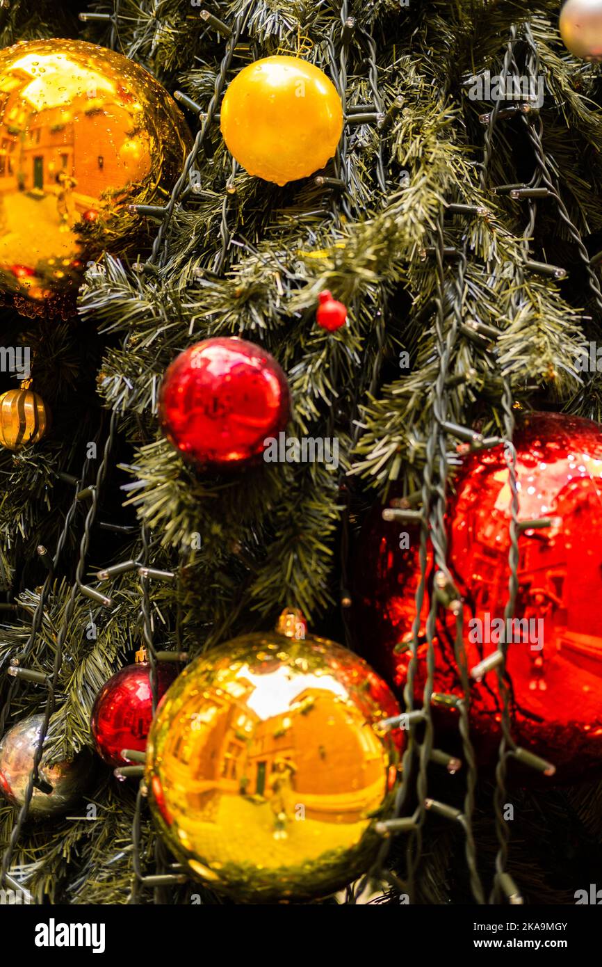Close-up vertical photo of a outdoor decorated Christmas tree with wet baubles Stock Photo
