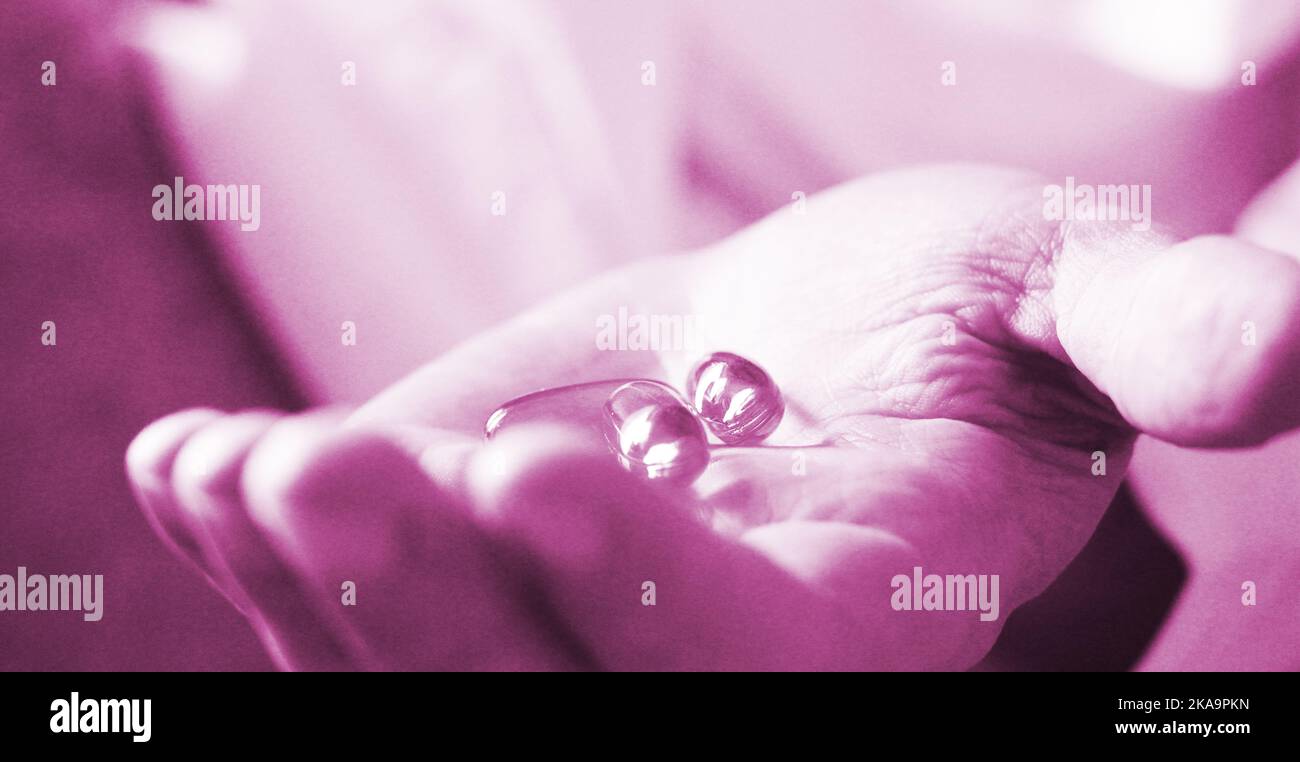 Soft gels pills with Omega-3 oil spilling out of pill bottle close-up iin aged woman hand. Healthcare concept . Selective foocus Stock Photo