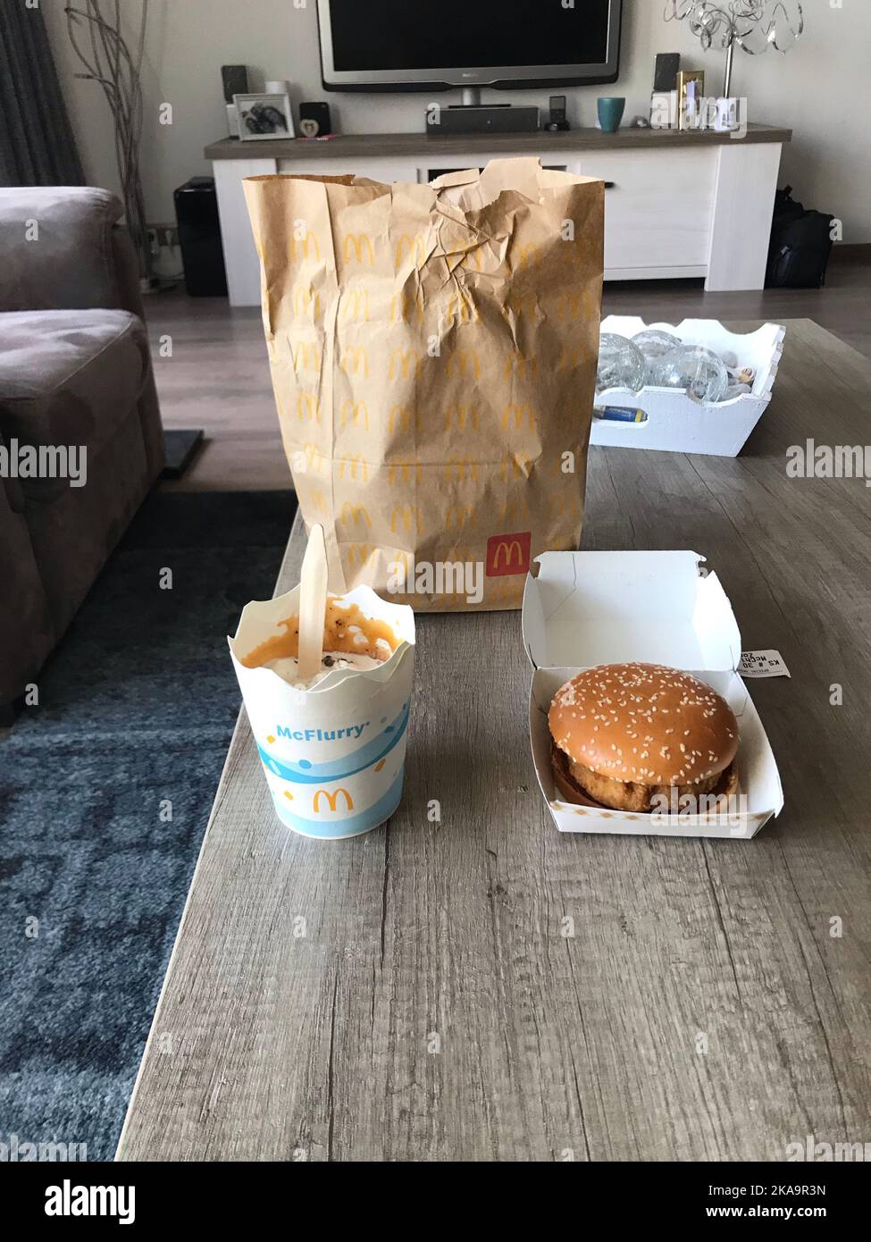A delicious McFlurry ice-cream and McChicken burger on a wooden table at home Stock Photo