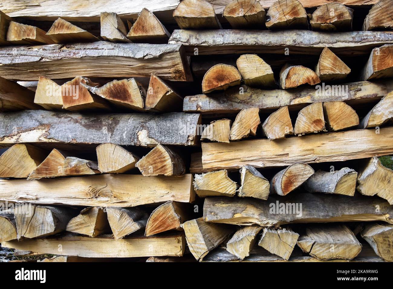 Chopped firewood is stacked in neat piles. Woodpile. Background. Close