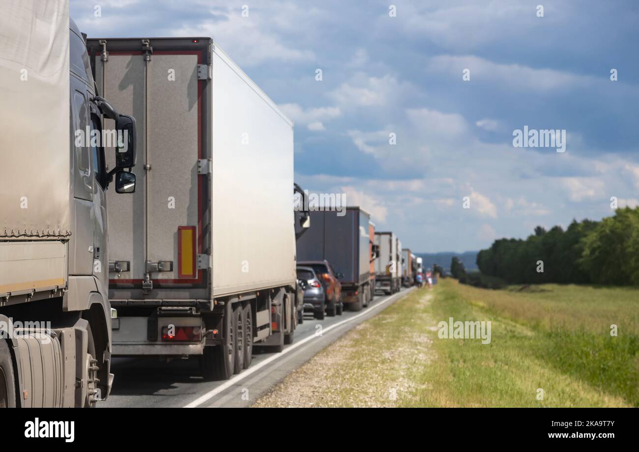 Trucks are stuck in traffic. A column of semitrailers on the freeway