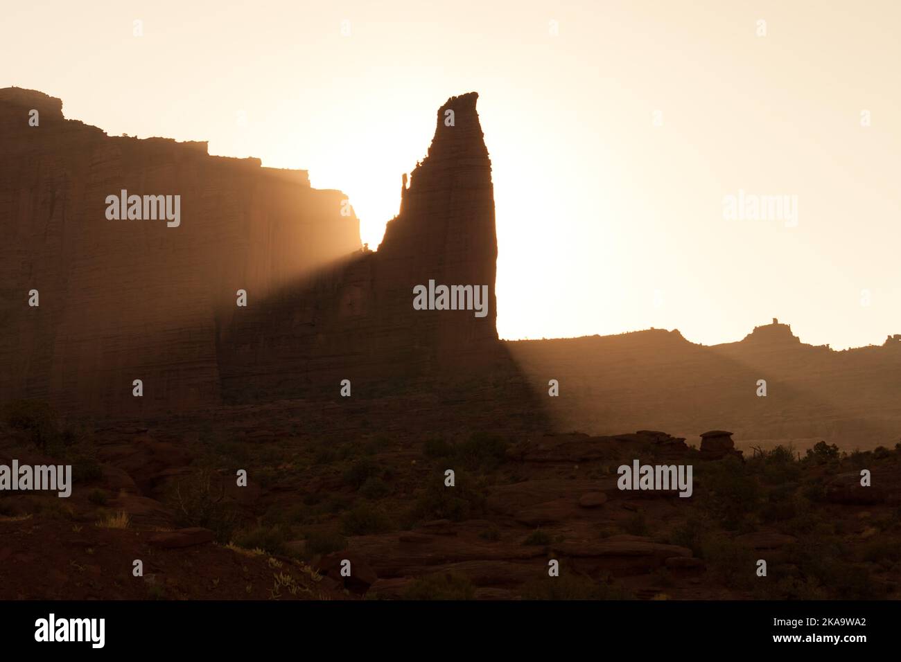 Sunrise silhouetting the Titan, a Cutler sandstone monolith in the Fisher Towers near Moab, Utah. Stock Photo