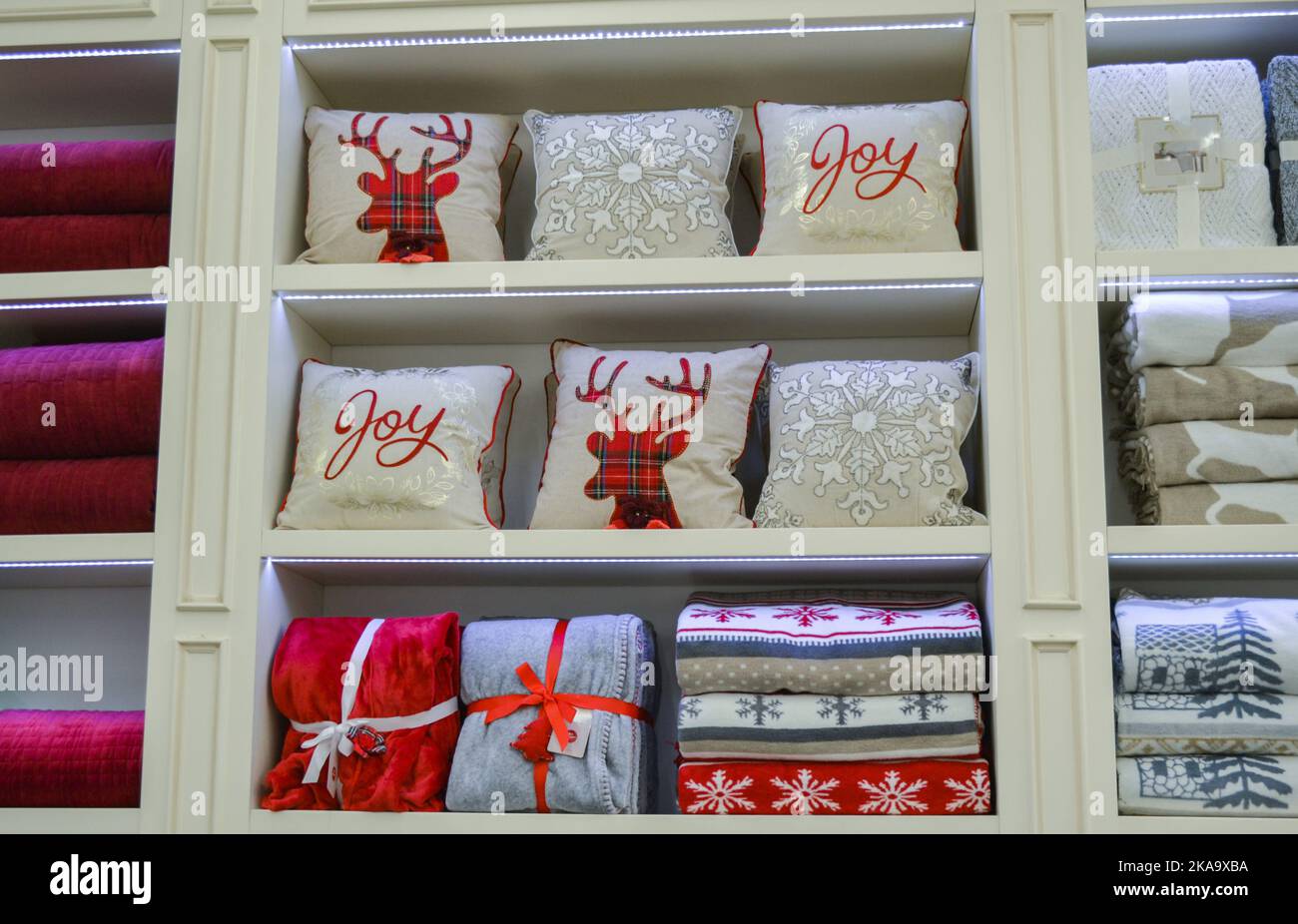 Moscow, Russia, November 2019: Christmas bed decoration on the shelves in the store: bed linen, blankets with winter urozor, decorative pillows with d Stock Photo
