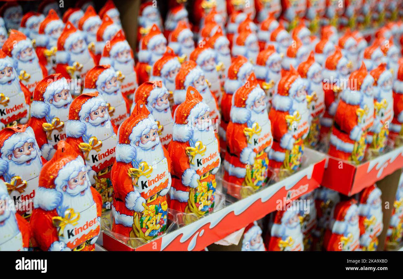 Moscow, Russia, November 2020: Lots of chocolate Santa clauses from Kinder in a bright orange and red outfit with a logo. Stock Photo