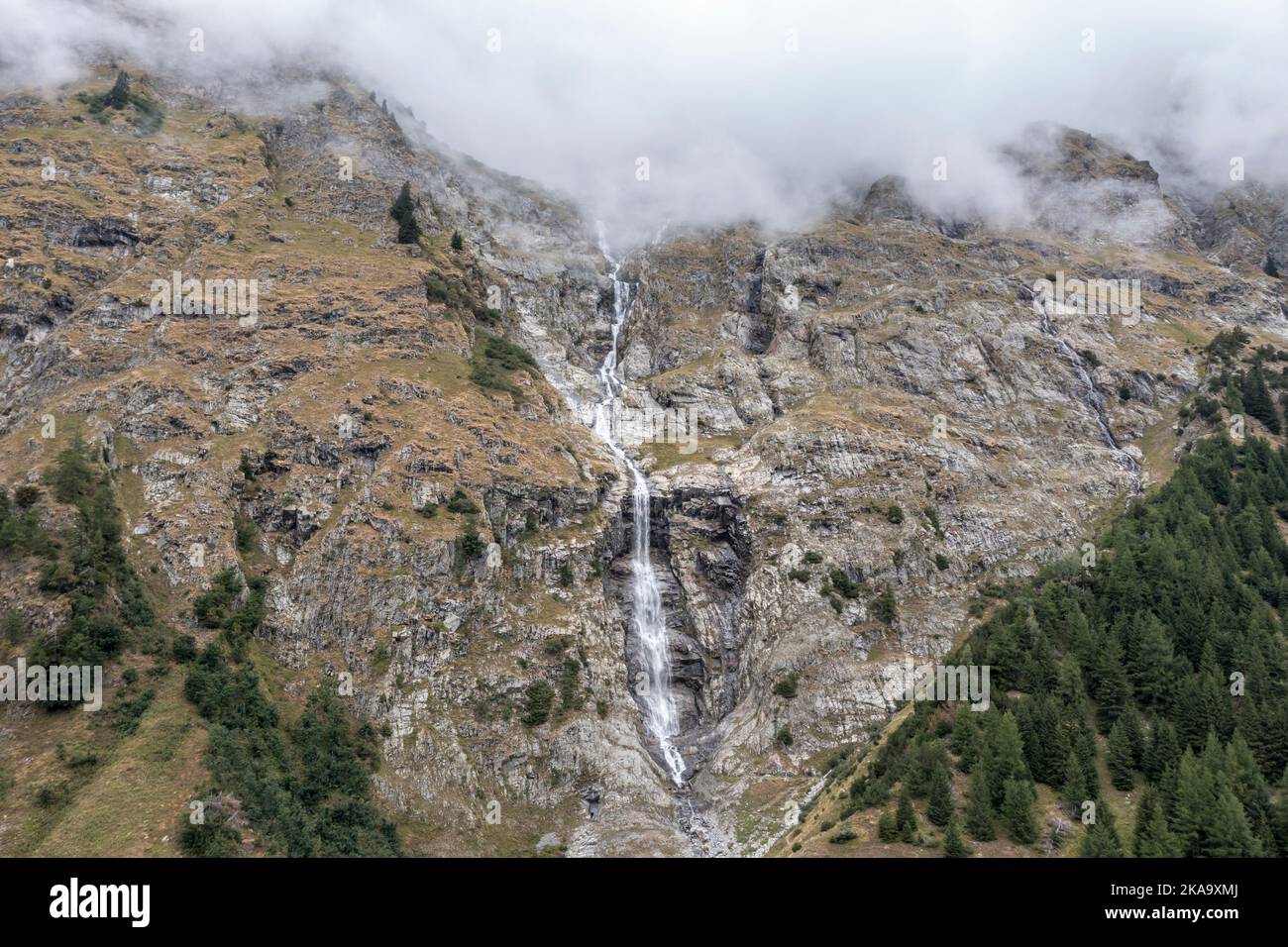 Val Ferret, waterfall at steep mountains, near Camping des Glaciers, path is part of Tour du Mont Blanc TMB,  Switzerland Stock Photo