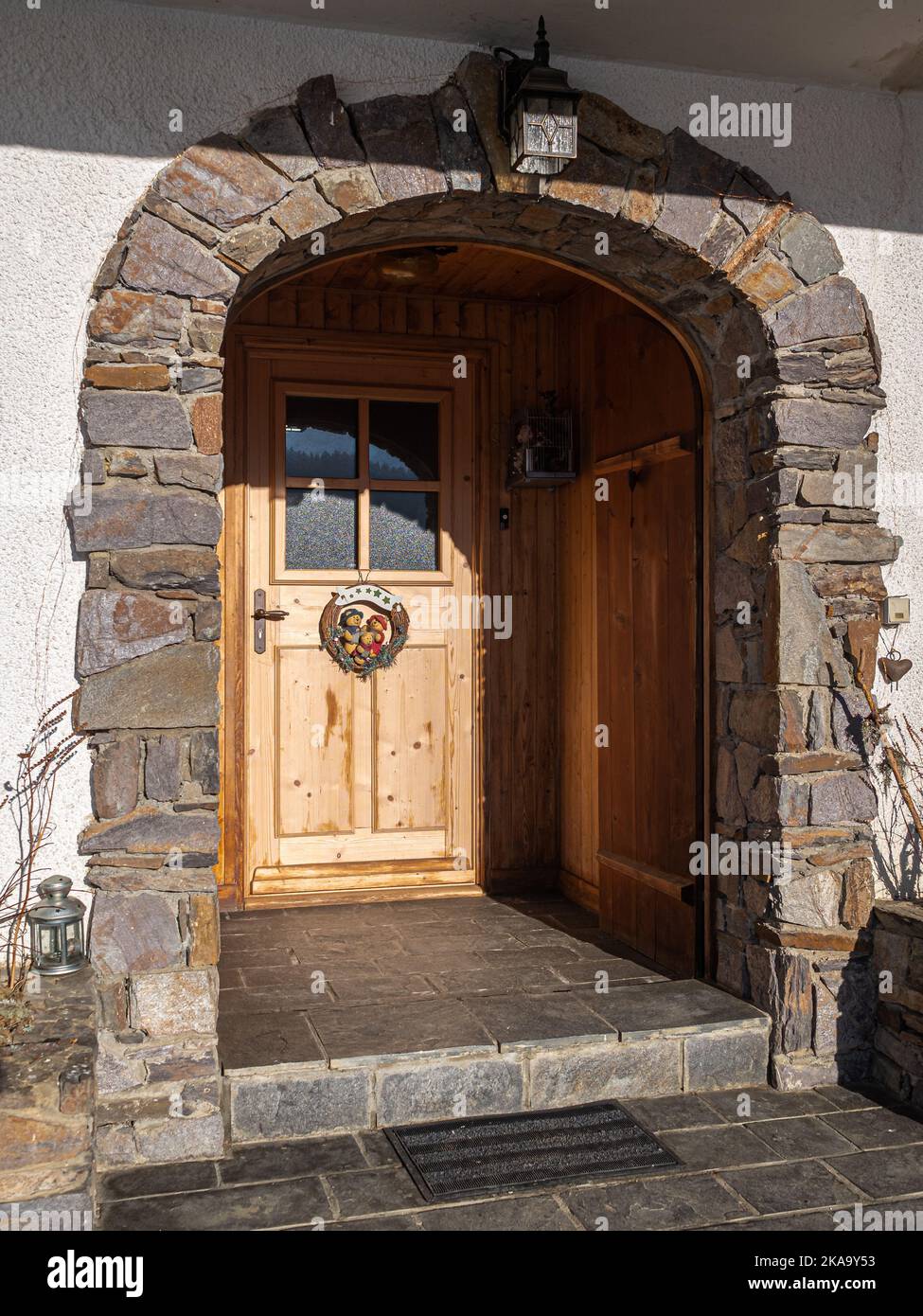 A vertical shot of an arched recessed entrance of a Savoyar chalet in