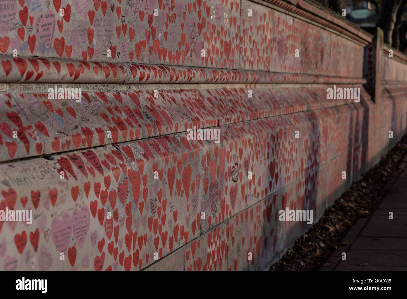 The National Covid Memorial Wall at dusk, kilometre-long wall on the Southbank, decorated with love hearts, names, dates, and messages, London, UK Stock Photo