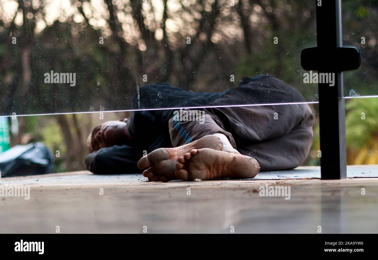 The dirty and hurt undersides of a black male's feet sleeping on the