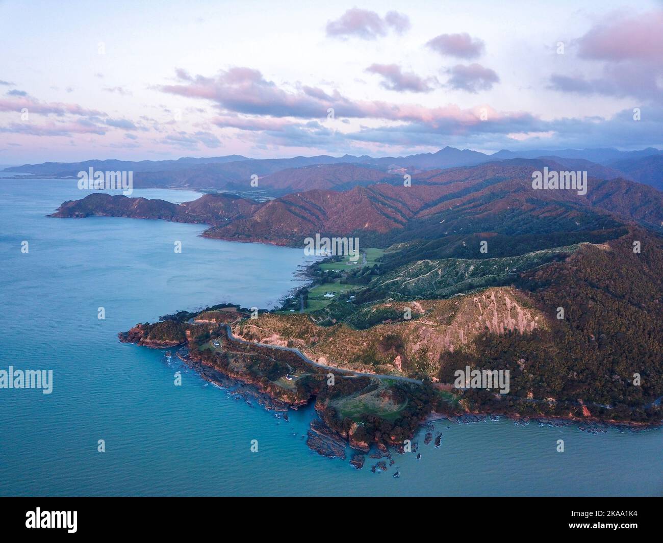 An aerial view of mountain landscape surrounded by water under blue