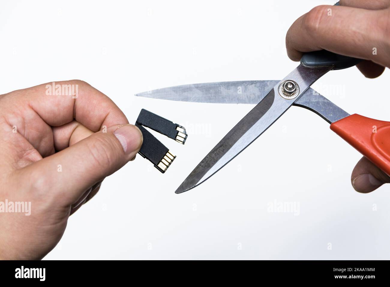 Cutting digital SD data card with heavy duty scissors Stock Photo