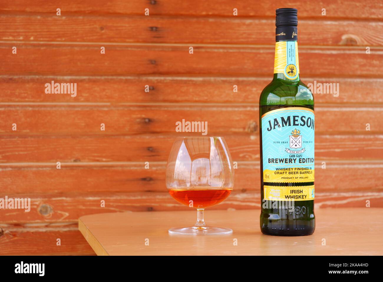 Whiskey served at snifter glass on table with wooden background Stock