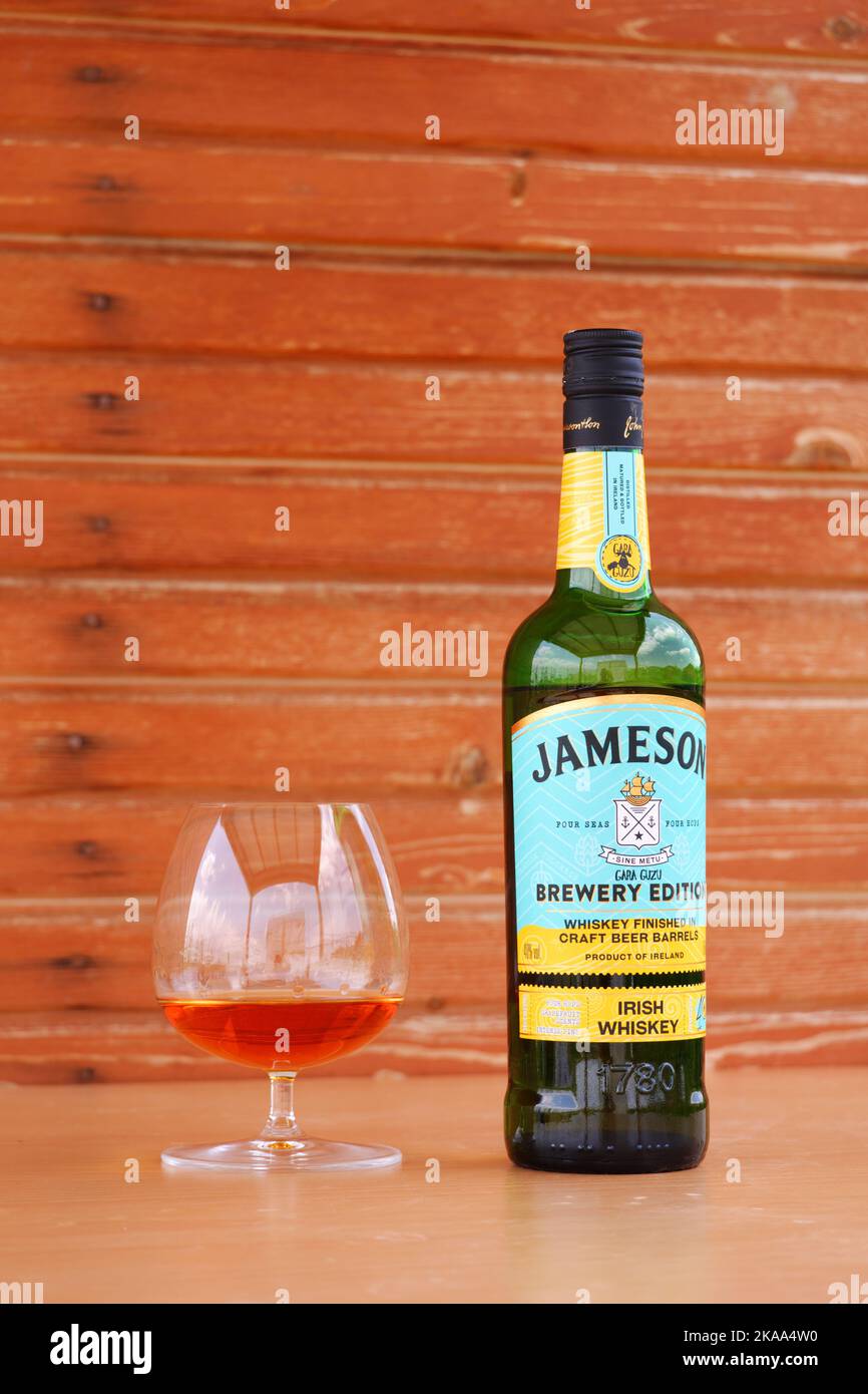 Whiskey served at snifter glass on table with wooden background Stock