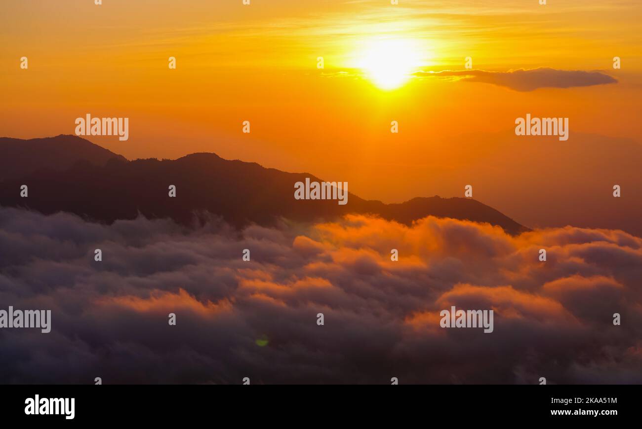 A golden sunrise mountain peak with a sea of clouds. Perfect for nature ...