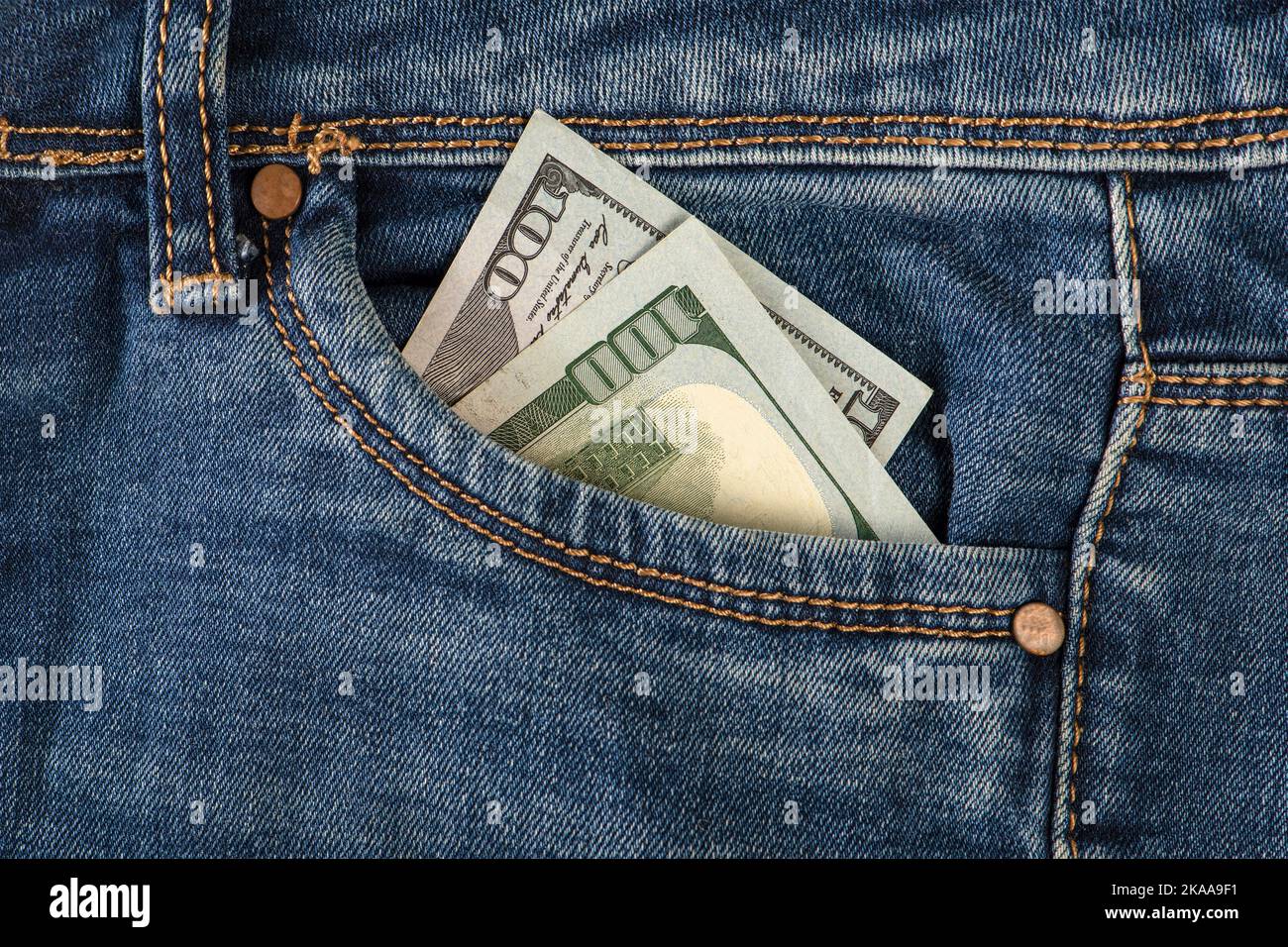 Stack of 100 dollar bills in jeans pocket. Money in the front pocket of jeans. The concept of investment, cash, wealth and profit Stock Photo