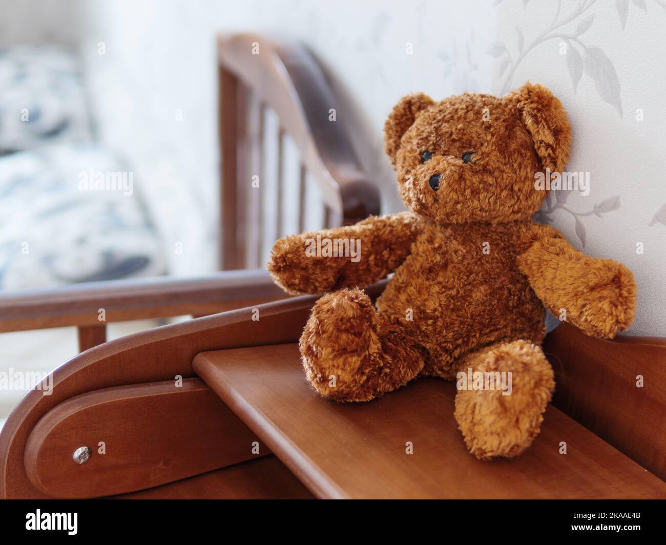 Teddy bear on wooden dresser. Plush toy in kids room. Stock Photo