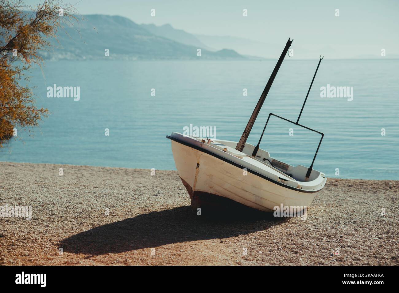 wooden boat alone on sea shore in the morning Stock Photo