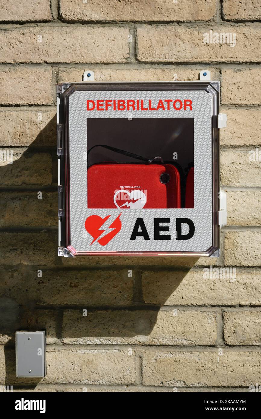 An outdoor AED cardiac defibrillator box isolated on brick background