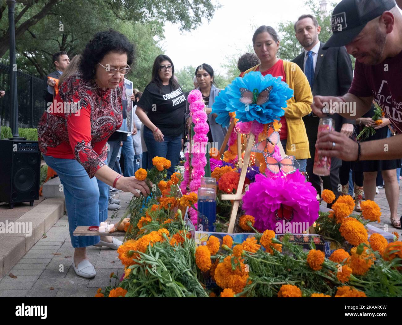 Austin mayoral candidate Celia Israel places a marigold on the memorial as families of the 21 victims of the May 24, 2022 Uvalde school massacre gather at the Texas Capitol and march to the Governor's Mansion in honor of their loved ones with a traditional Dia de los Muertos ceremony on November 1, 2022. The traditional Mexican holiday translates into 'Day of the Dead'. Credit: Bob Daemmrich/Alamy Live News Stock Photo