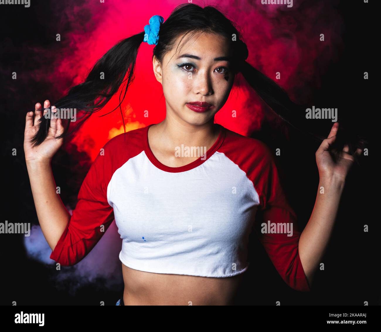 Young Woman in Harlequin Costume Standing in Front of Brightly Lit Fog