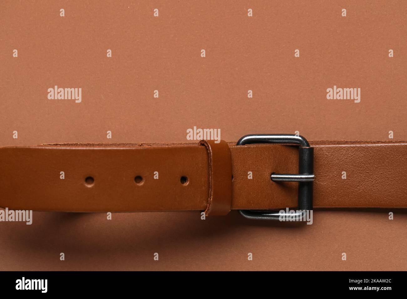 Leather belt with buckle on brown background Stock Photo