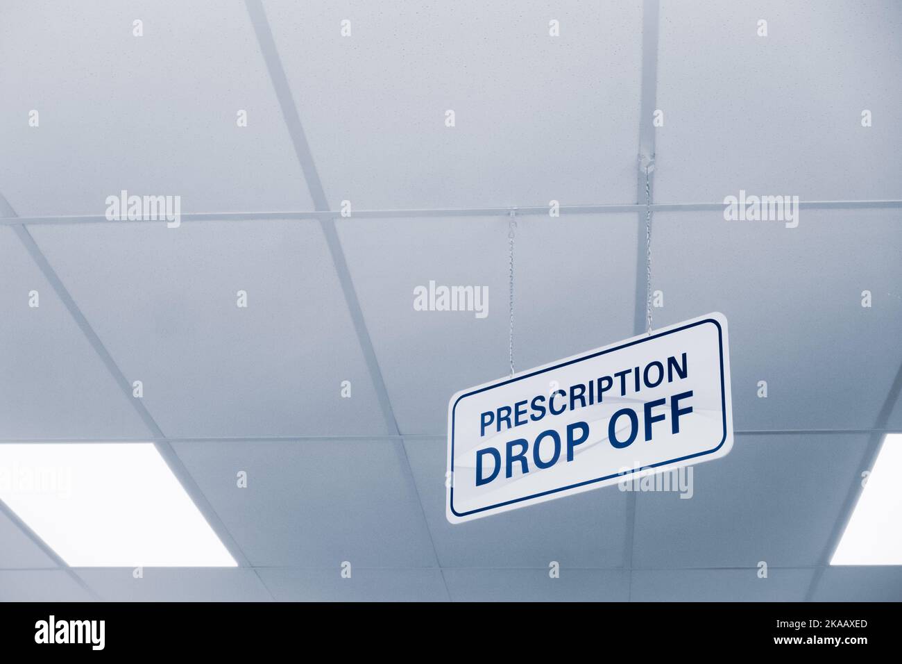 Plain white and blue prescription dropoff sign hanging from an