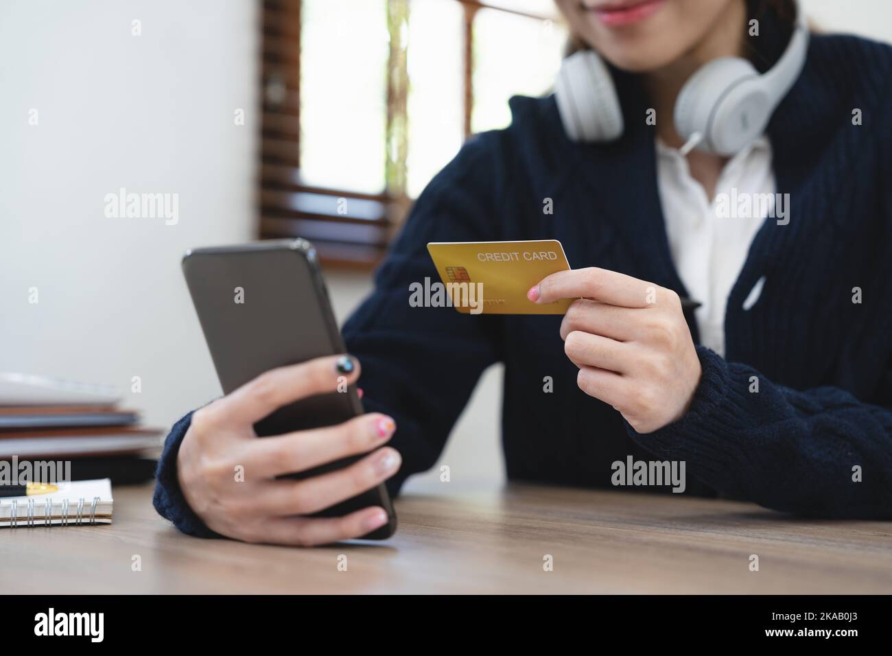 Asian girl making online payment using mobile phone for shopping at home. Stock Photo