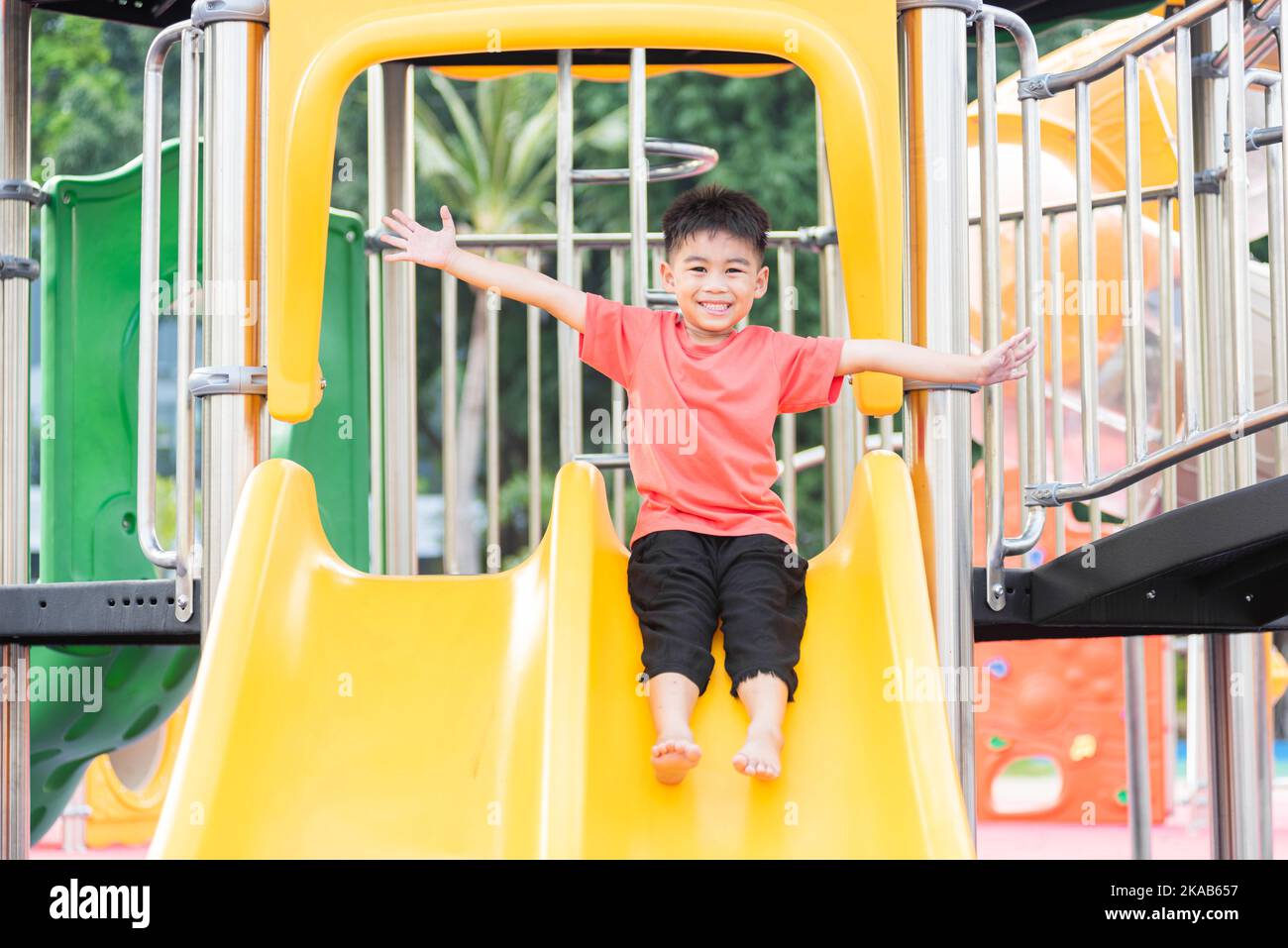 Asian child smiling playing on slider bar toy outdoor playground Stock ...