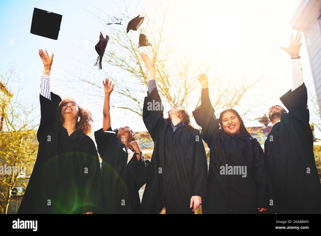 The sky is the limit. a group of students throwing their caps into the ...