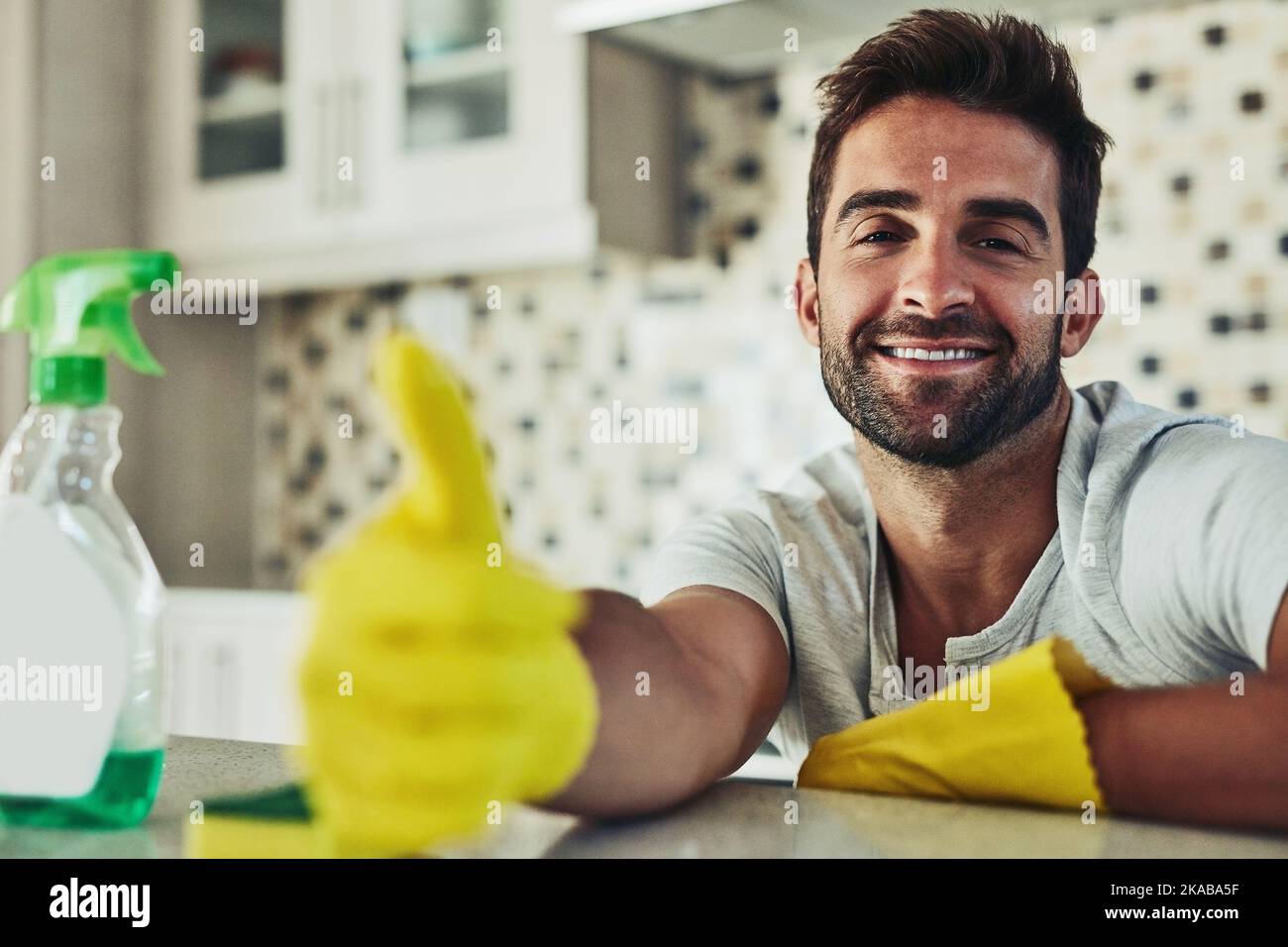 Housework is not just for women. a handsome young man cleaning his home