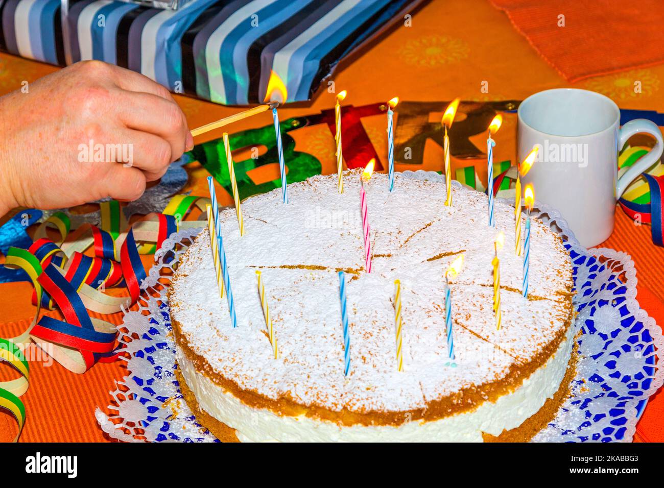 lighting the birthday candles on the cake Stock Photo Alamy